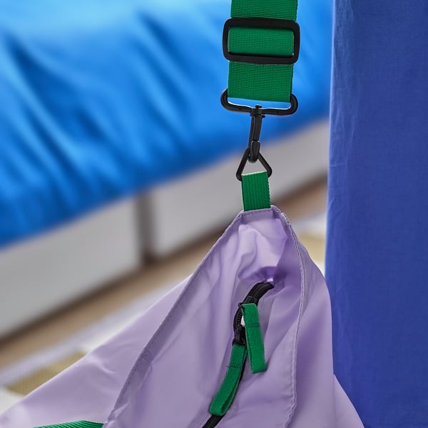 Green straps and black clips on a purple tent.