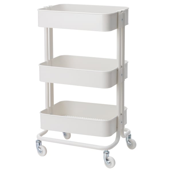 A white IKEA RÅSKOG three-tier rolling utility cart with metal construction and casters for mobility.