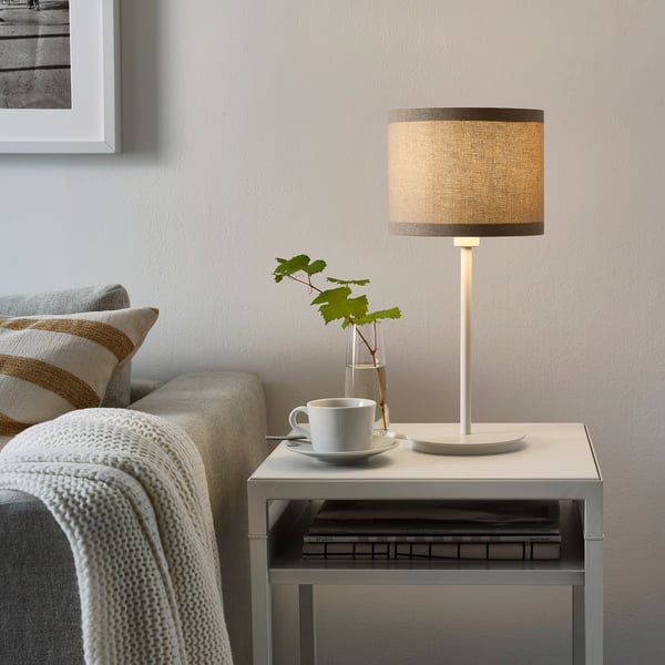 Beige linen RINGSTA table lamp on side table, cosy living room light.