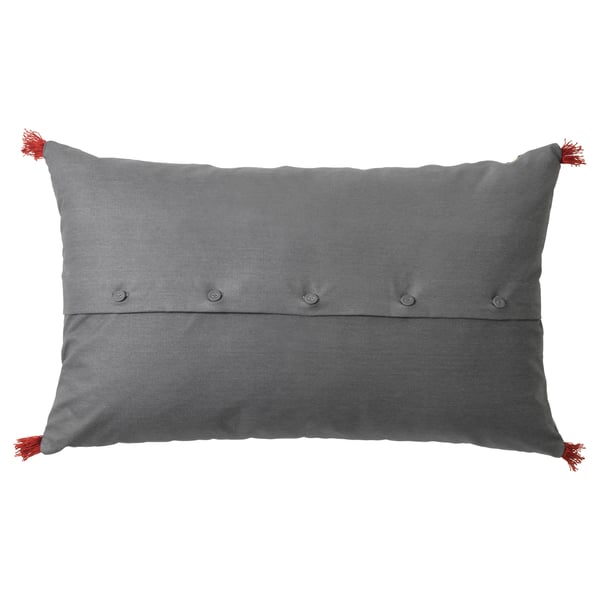 Grey rectangular pillow with red tassels, buttoned closure, embroidered pattern.