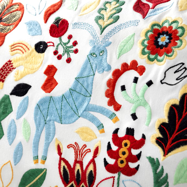 Embroidered cushion with vibrant colours and intricate designs, featuring various flora and fauna, showcasing high-quality craftsmanship.