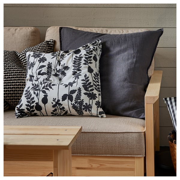 Wooden bench with white & grey floral, solid grey, and chequered throw pillows.