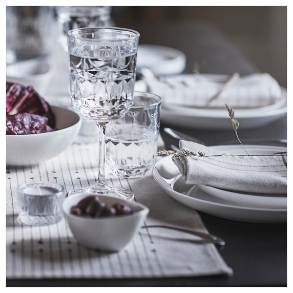 Elegant table setting with SÄLLSKAPLIG glassware, white plates, and bowls. Glasses, plates, and bowls neatly arranged.