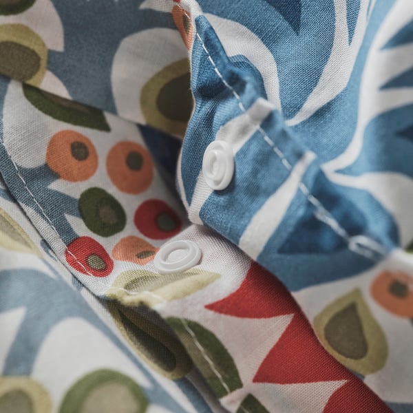Colourful duvet cover with blue, red, and green floral patterns. Shows concealed press studs for secure fastening.