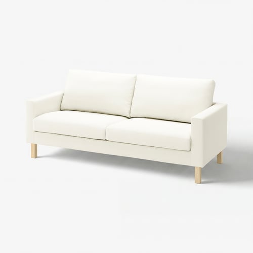 The SALTSJÖBADEN sofa, a white couch with a slim, modern design. It has wooden legs and is upholstered in cotton fabric.
