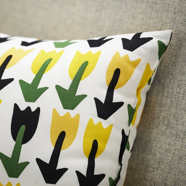 Colourful tulips pillow on grey fabric.