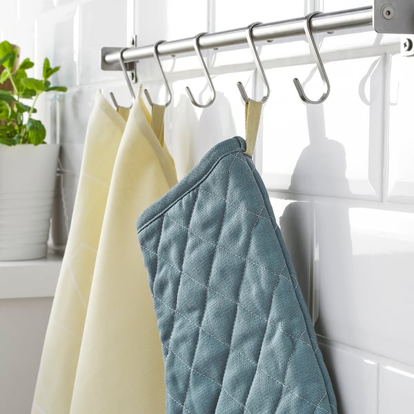 Kitchen hooks holding blue and beige dish towels in a tidy setup.
