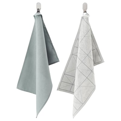 Two SANDVIVA cloths hang, one solid green, one white with grey triangles, made of 50% cotton and 50% lyocell.