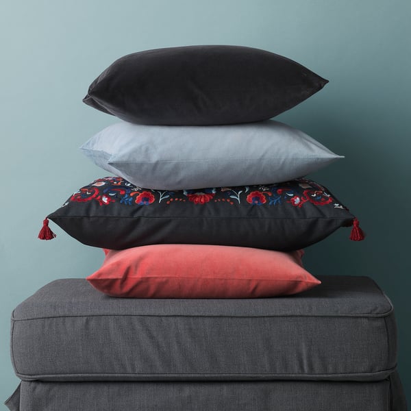 Stack of four throw pillows on a couch, showcasing different colours and patterns, likely made of soft cotton velvet.