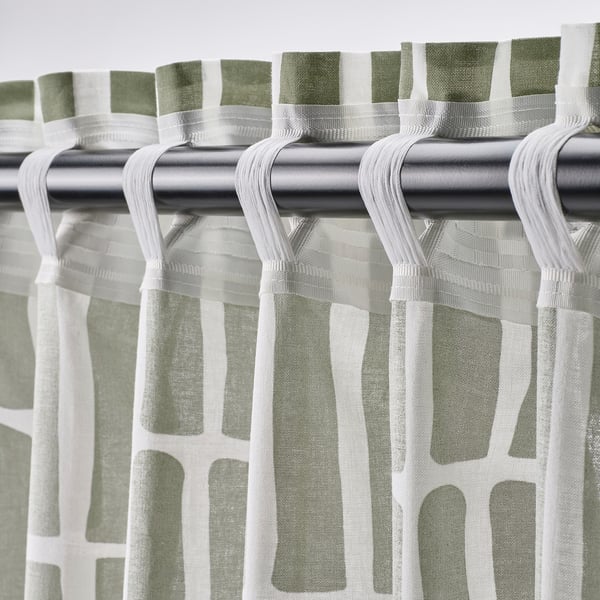 Curtain rod with hooks; geometric patterned curtains hang, offering light philtre and privacy.