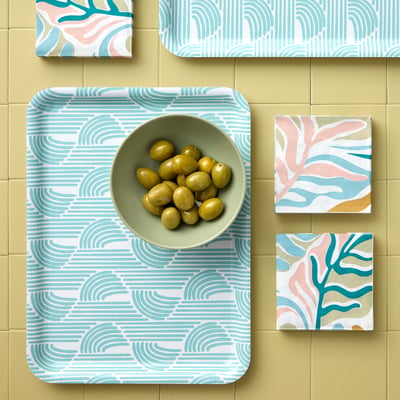 A decorative tray holds a bowl of olives on a colourful backsplash with patterned tiles.