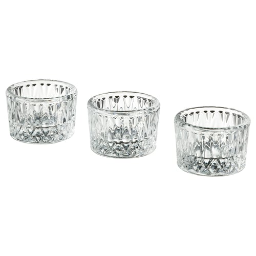 Three clear glass candle holders in varied sizes, featuring intricate cut designs, arranged in a neat row.