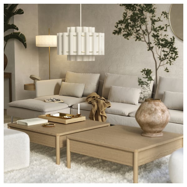 Modern living room with light grey SÖDERHAMN sofa, wooden coffee table, white pendant lamp, and plants.