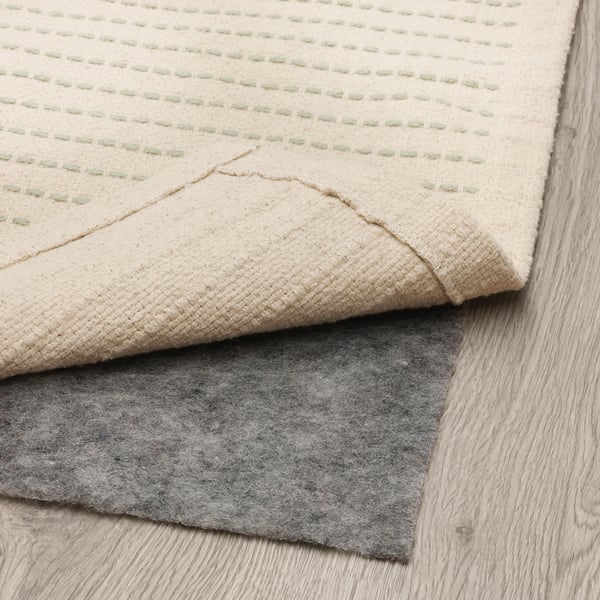Light cream rug with subtle green stripes. Anti-slip felt backing visible, ensuring safety and stability on floors.