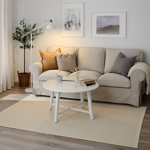 Light green STARREKLINTE rug in living space, complements neutral sofa and coffee table, adds warmth and texture.