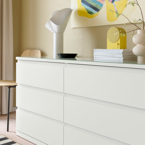 White chest of drawers with glass top. Protects surface and adds modern look.