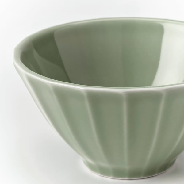 A close-up of a stoneware bowl with a glossy, vertical ribbed design in greenish-grey, showcasing its smooth and elegant finish.