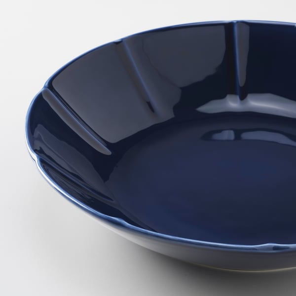 Blue bowl with glossy finish and wavy rim.