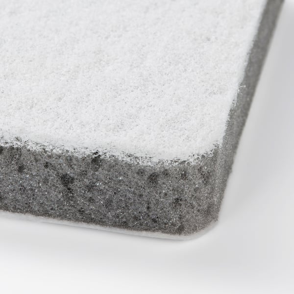 Close-up of dual-texture cleaning sponge, soft side and rough side on a white background.
