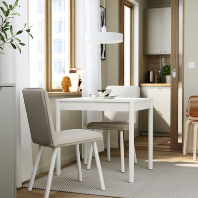 Modern white dining set with extendable table and 2 upholstered chairs. Minimalist design with soft edges.