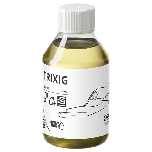 A white bottle of TRIXIG plant oil with a yellowish liquid inside, featuring musical notes on the label.