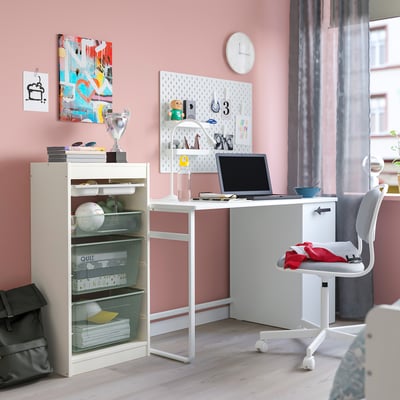 Bedroom with TROFAST storage, desk, laptop, and chair. Mesh compartments, wall art, trophy.