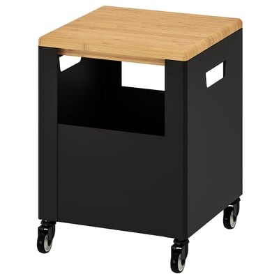 A black IKEA TROTTEN rolling storage with a bamboo top. It has open sides, castors, and handles for easy movement.