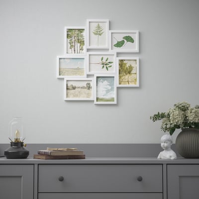 A wall display featuring seven framed art cards showcasing various nature scenes and botanicals, arranged in a collage on a grey wall above a dresser.