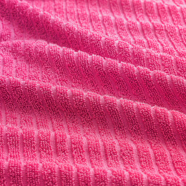 Bright pink towel, soft cotton terry, ribbed texture, high quality feel.