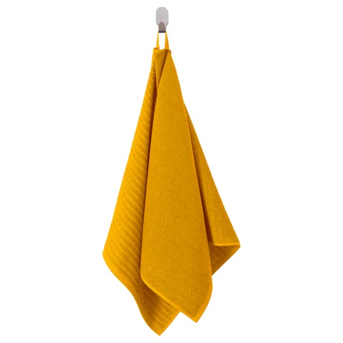Bright yellow VÅGSJÖN towel hangs neatly from a hook, featuring soft, absorbent cotton terry with striped texture.