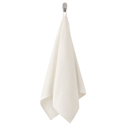 A white VÅGSJÖN cotton towel hangs neatly on a hook, featuring a stripe pattern and terry texture.