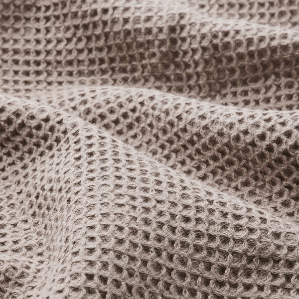Close-up of waffle-textured towel in light grey and brown, soft and tightly woven.