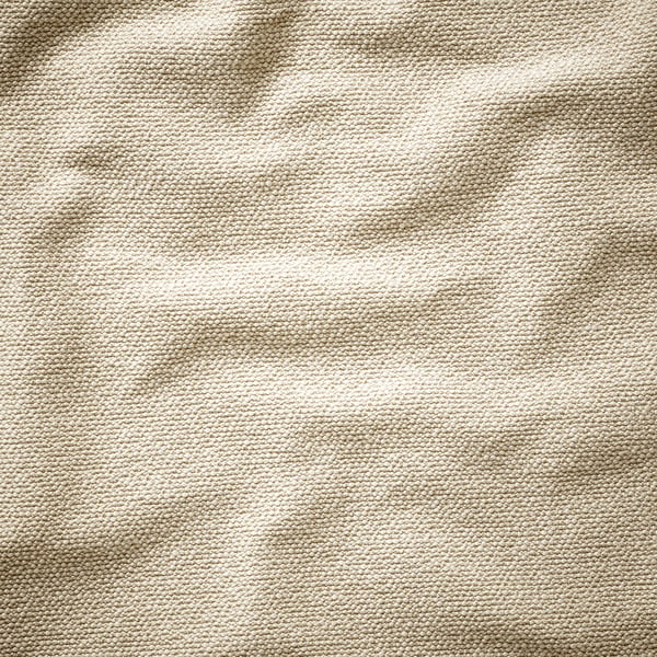 Close-up of beige knit fabric. Textured with visible loops, soft and slightly uneven.