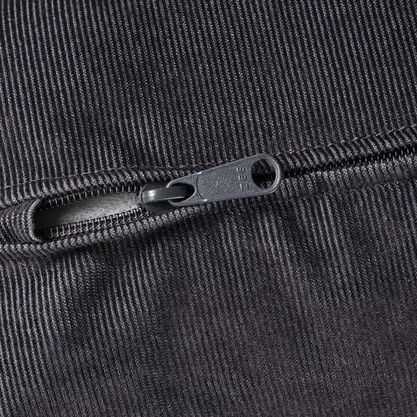 Close-up of a smooth, black fabric with a zip featuring ykk branding, indicating high-quality material.