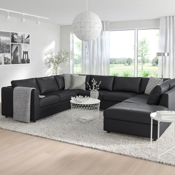 Modern living room with large black l-shaped VIMLE sofa, white pendant light, and big windows.