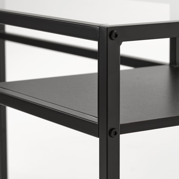Modern black metal shelf unit with two black shelves and a glass top, showcasing sturdy construction.