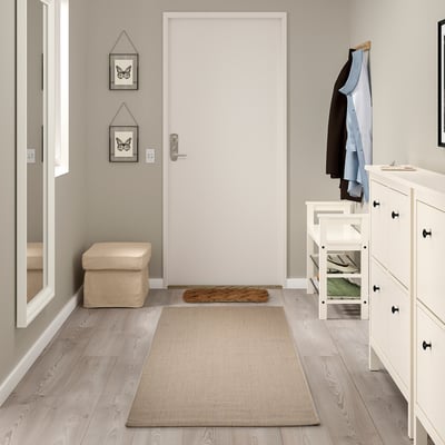 Neutral-toned VODSKOV jute-sisal rug in entryway, large rectangular size, surrounded by furniture.