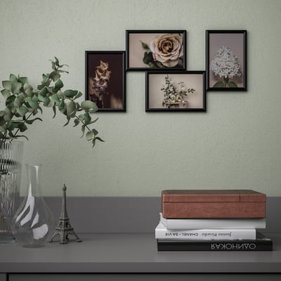 Styled wall art display featuring floral pictures above a shelf with books and vase.