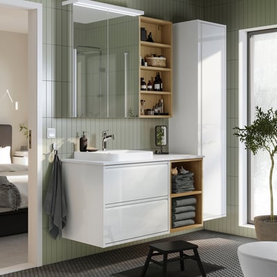 White vanity with marble, mirror cabinet, stool, & towels. Modern decor.