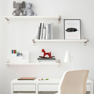 Modern white kids study area. BERGSHULT shelf holds books, toys, & decor. Desk with chair, lamp, & colourful accessories.