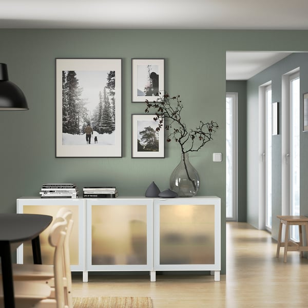 Modern living room with BESTÅ sideboard, photos, and vase.