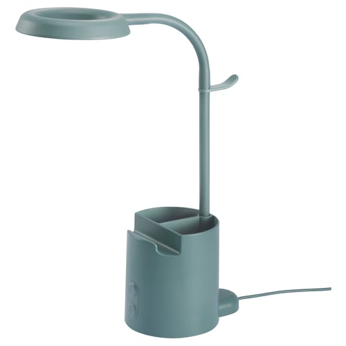 BRUNBÅGE lamp in sage green with adjustable arm, built-in pen holder, phone holder, and headphone hook. Modern, functional design.