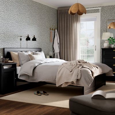 Black oak fägelfjället bed with nightstands & chest in large room.