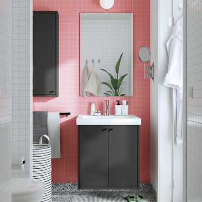 Modern bathroom with black HAVBÄCK vanity, pink tiles, white counter, large mirror, and dark finish.