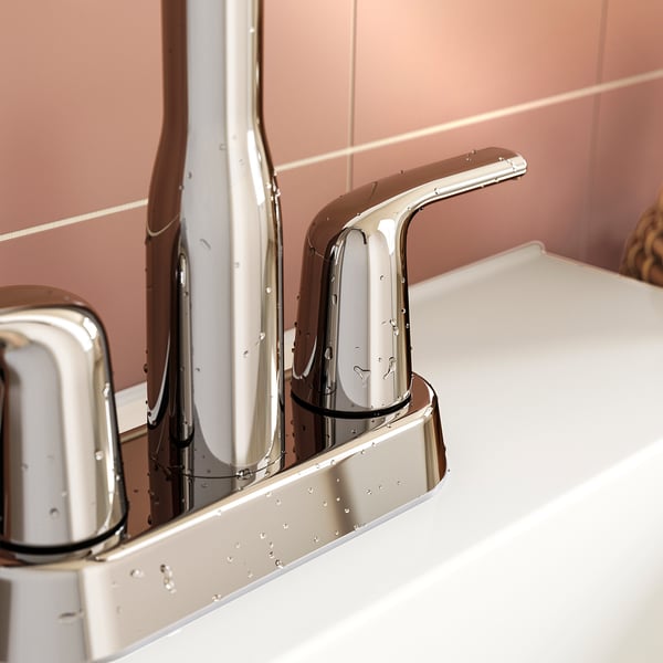 Modern chrome tap with sleek curve, mounted on white sink, reflecting clean design.