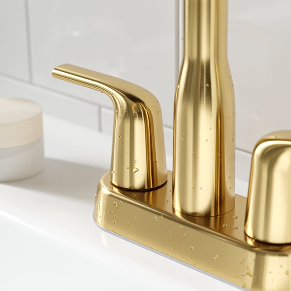 Golden tap with sleek design, metallic finish, smooth curves; mounted on a countertop, water droplets visible.