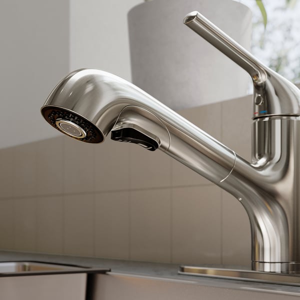 Modern kitchen tap with sleek design, metallic finish, and pull-out spray head, mounted on a clean, tiled backsplash.