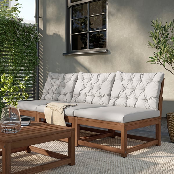 Modern outdoor sectional, light grey cushions, wooden frame, cosy corner setup.