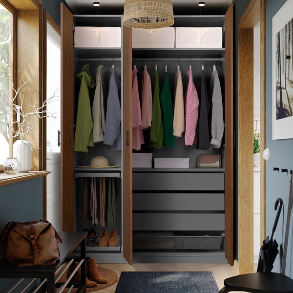 Modern wardrobe with coloured sweaters, coats, shelves, leather bag, and umbrella stand.
