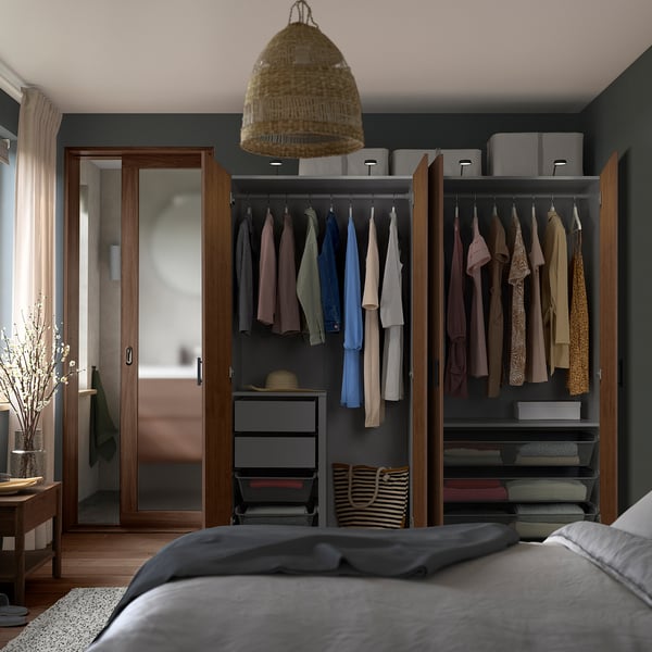 Modern bedroom with mirrored PAX wardrobe, pendant light, and grey bedding.